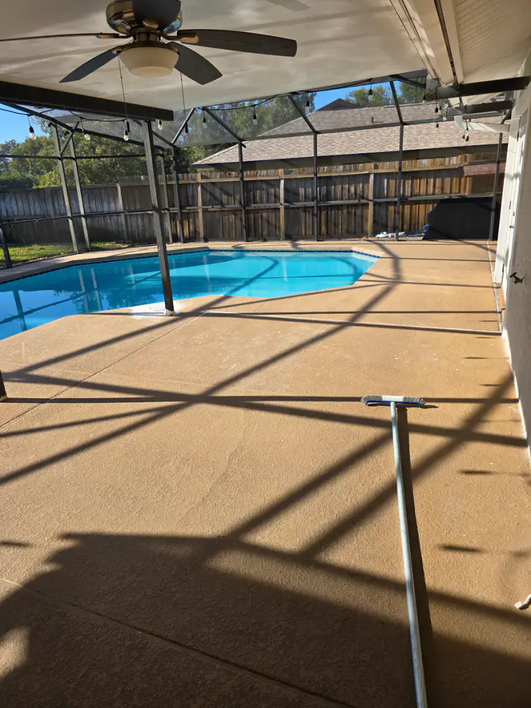 Wide completed view of a light neutral coating around a screened residential pool.